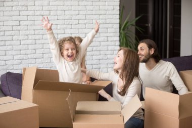 Happy family with cardboard boxes at their new home clipart