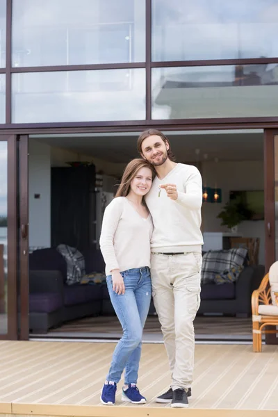 Par i kärlek står på terrassen i nytt hus — Stockfoto