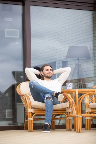 Positivo uomo millenario seduto sulla poltrona all'aperto a casa — Foto Stock