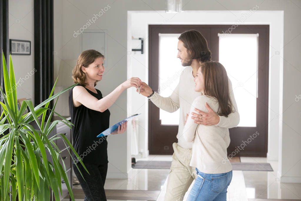 Happy couple receiving house keys from realtor