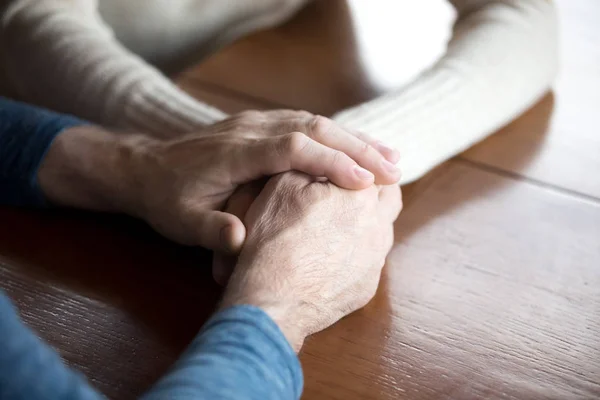 Primer plano de pareja de ancianos tomados de la mano expresando el cuidado eterno —  Fotos de Stock