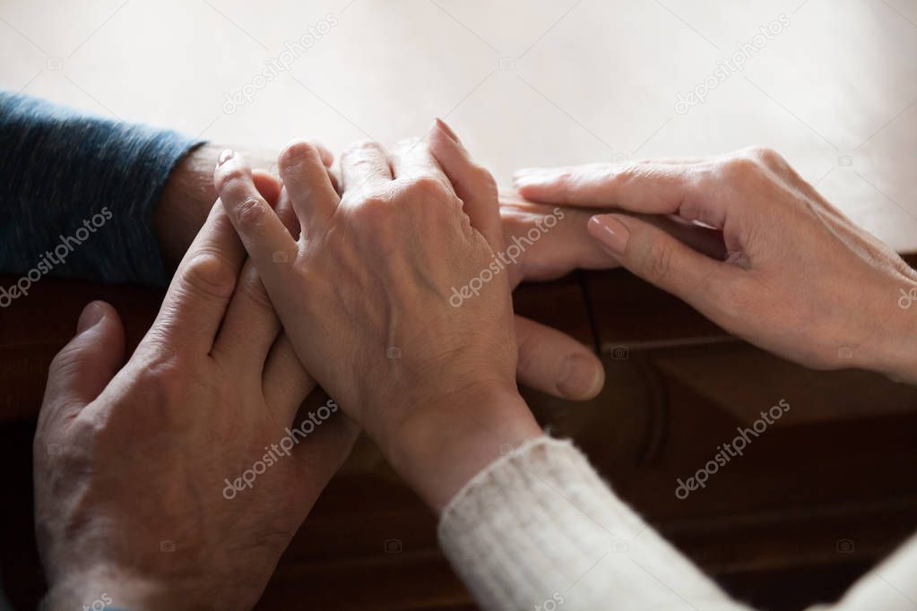 Close up of aged sensual couple caressing hands at home