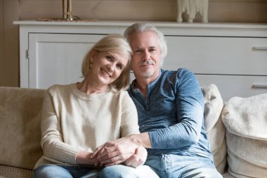 Mutlu yaşlı çift el ele tutuşarak resim için poz portresi