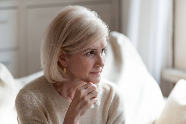 Upset senior woman sorrow for something at home