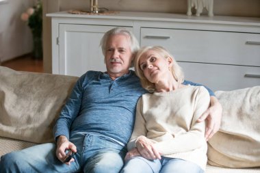 Mutlu çift Tv izlerken kanepede rahatlatıcı yaşlı