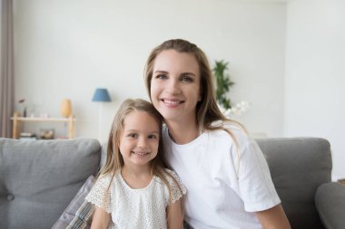 Mutlu anne ve çocuk kızı kanepede oturan portresi