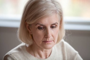 Close up of sad senior woman remembering missing past  clipart