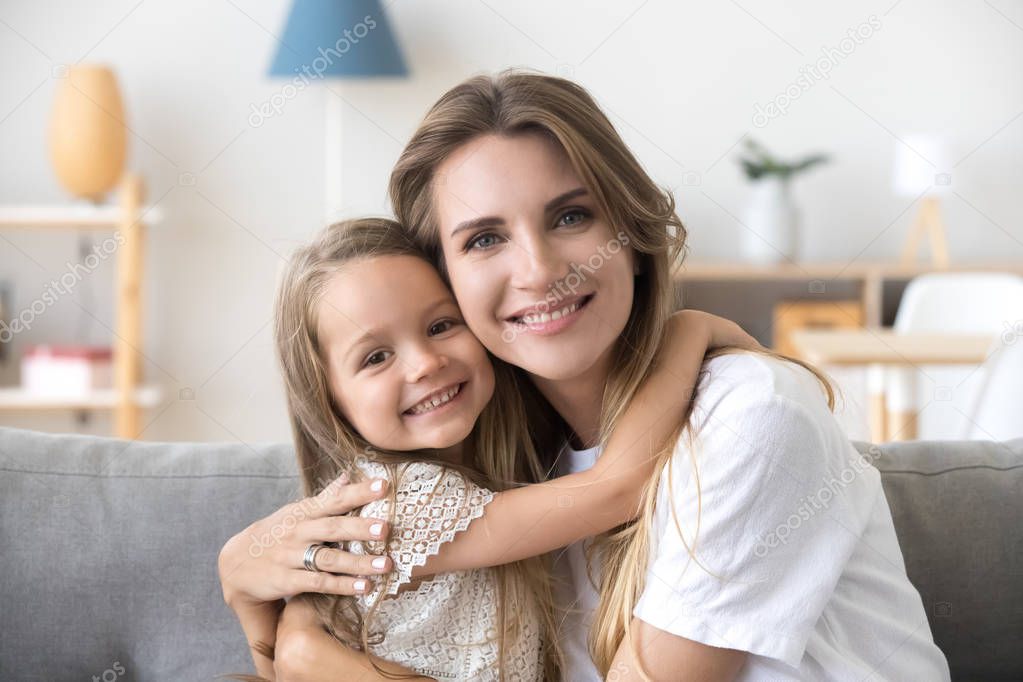 Happy loving young mother hugging little preschool daughter, por