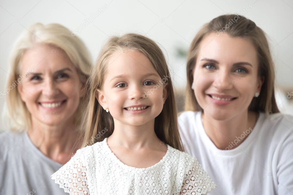 Adorable little girl looking at camera with mom and grandma