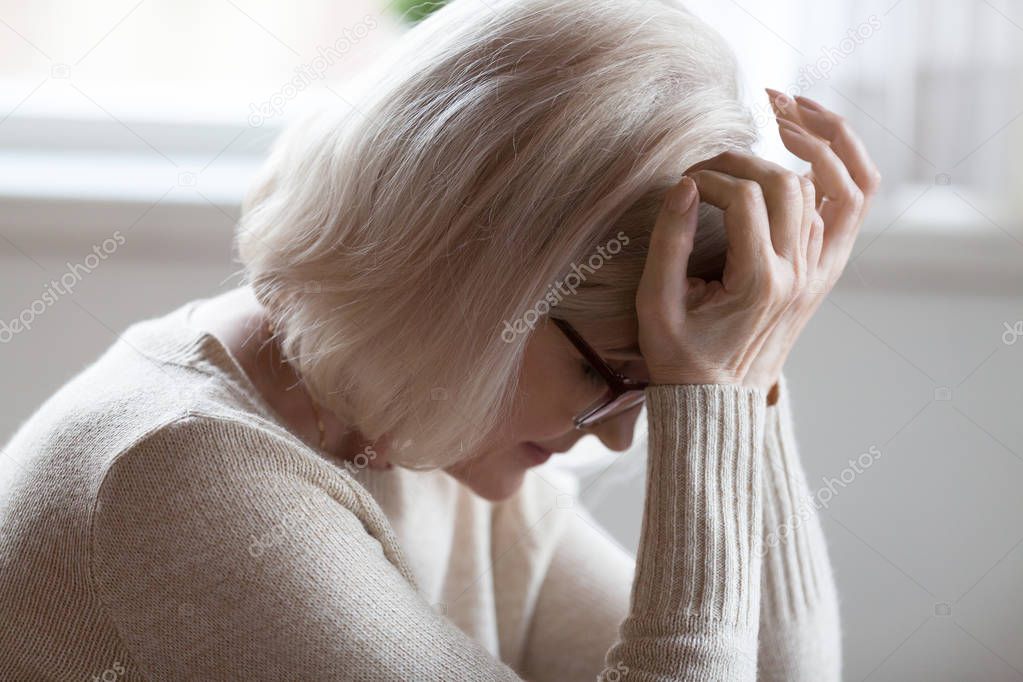 Elderly woman feeling unwell suffering from pain or dizziness