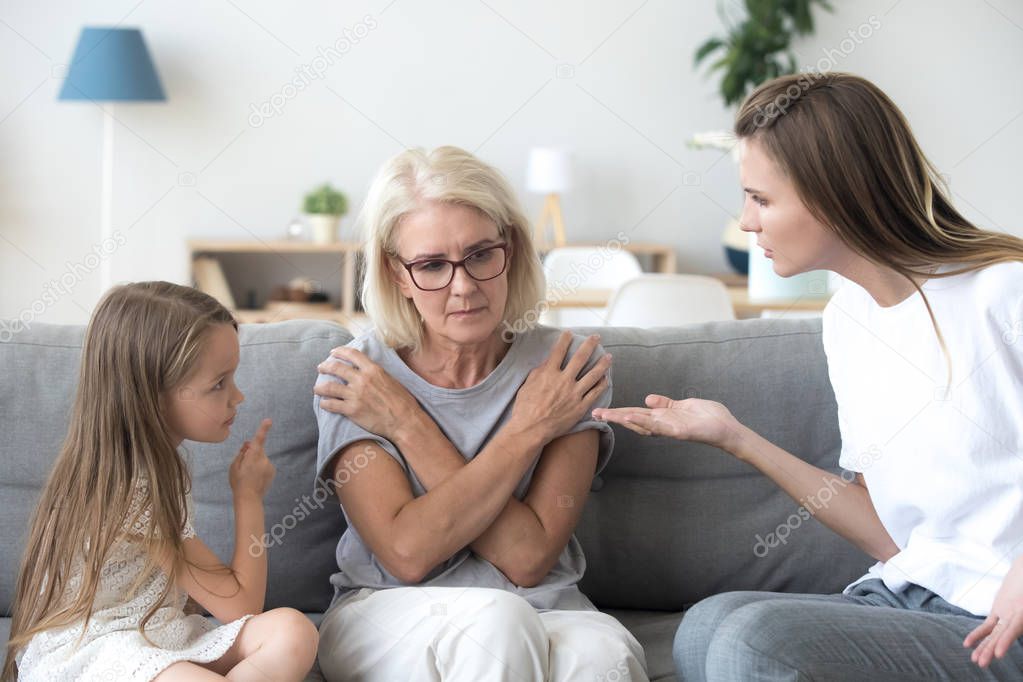 Young mother and little daughter scolding upset grandmother, gen