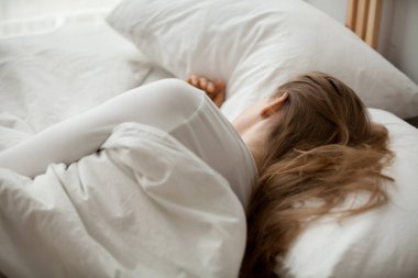 Kadın uyku üzerinde beyaz çarşaf rahatlatıcı rahat yatak