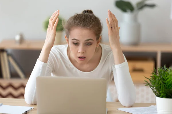 Menina frustrada lendo notícias chocantes no laptop — Fotografia de Stock