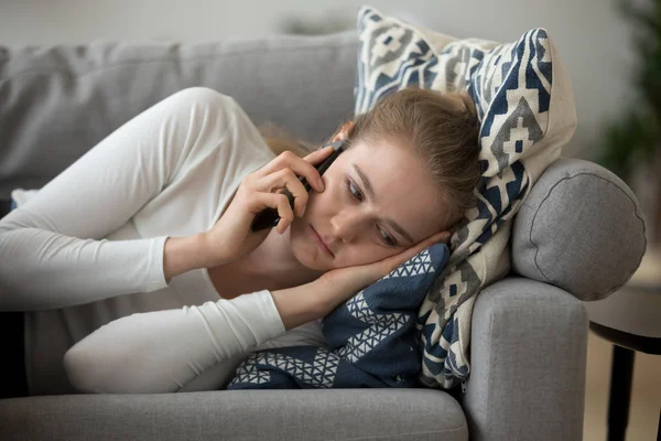 Mérges lány feküdt a kanapén, hogy kellemetlen telefon beszélgetés — Stock Fotó
