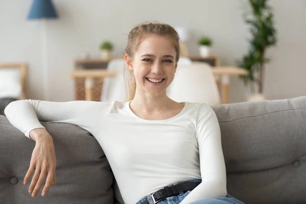 Портрет улыбающейся женщины, сидящей на диване — стоковое фото