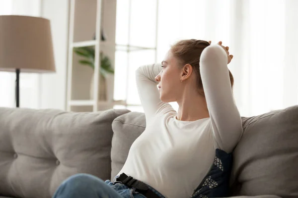 Giovane femmina rilassarsi sul divano guardando a distanza pensando — Foto Stock