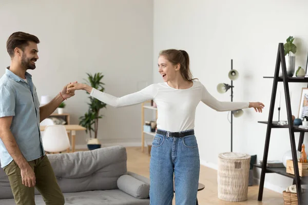 Happy couple have fun dancing in living room together