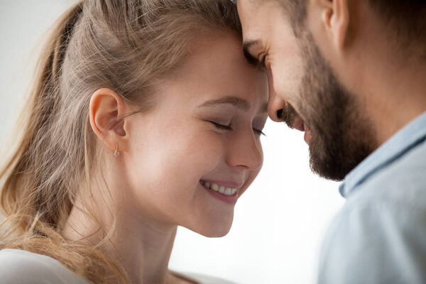 Close up of loving couple touching forehead enjoying tenderness