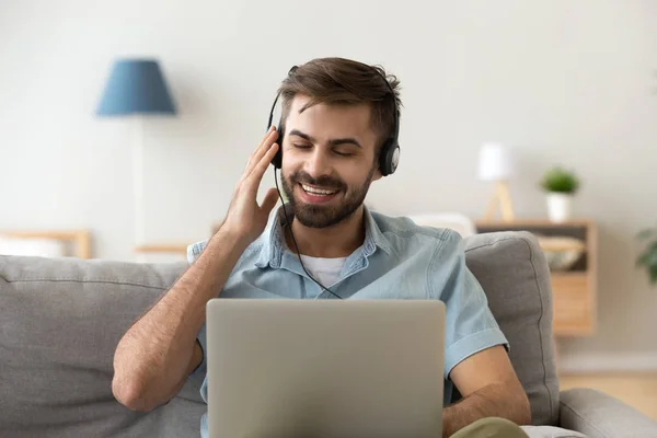 Возбужденный мужчина в наушниках слушает музыку онлайн — стоковое фото