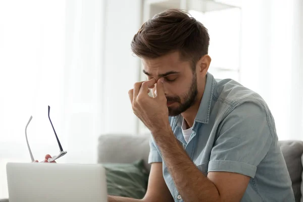 Tired man take off glasses suffering from blurry vision — Stock Photo, Image