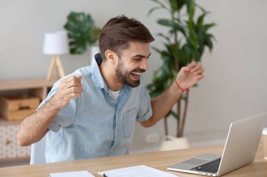 Mutlu bir adam üstünde laptop şaşırtıcı haberler okuma heyecanlı