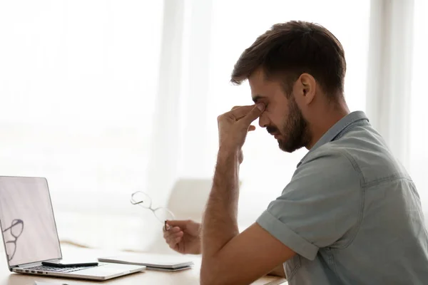 Hombre cansado se siente mal sufriendo de dolor de cabeza —  Fotos de Stock