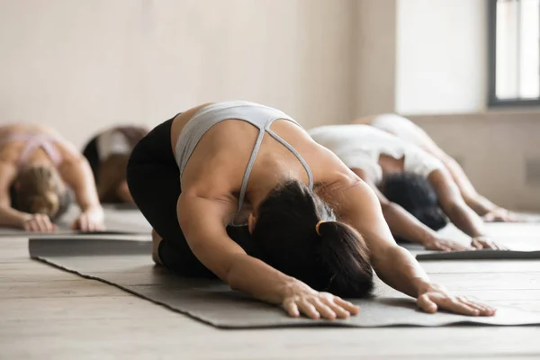 Group of sporty people practicing yoga lesson, doing Child exerc — Stock Image Group of sporty people practicing yoga lesson, doing Child exerc Stock Photo