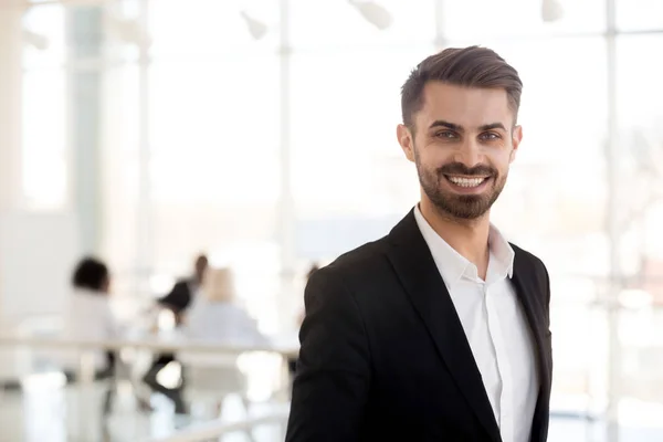 Smiling millennial businessman looking at camera posing in offic — Stock Photo, Image