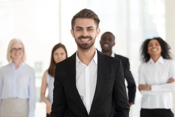 Smiling young businessman looking at camera posing with diverse — Stock Photo, Image