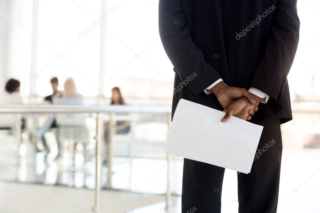 Rear view at african businessman holding papers preparing for pe