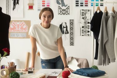Kendine güvenen Moda Giyim Tasarımcısı ayakta iş yerinde portresi