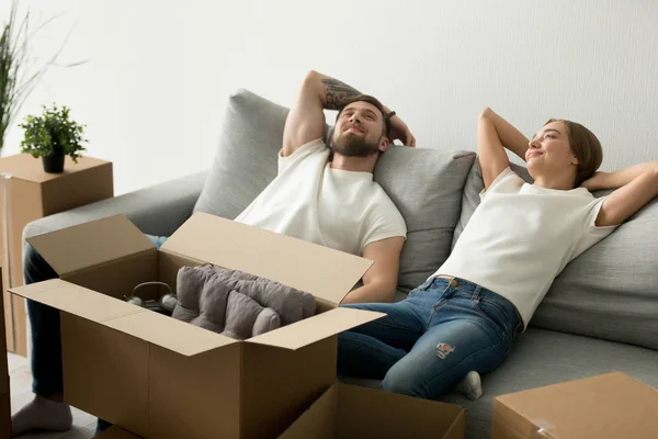 Calm relaxing couple sitting together on couch at new house — Stock Photo, Image