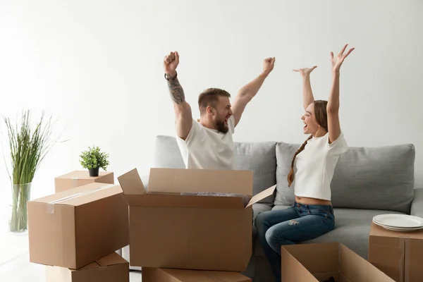 Happy excited couple sitting together on couch celebrating movin — Stock Photo, Image