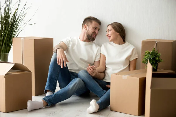 Tired couple sitting leaning back against wall in new apartment — Stock Photo, Image