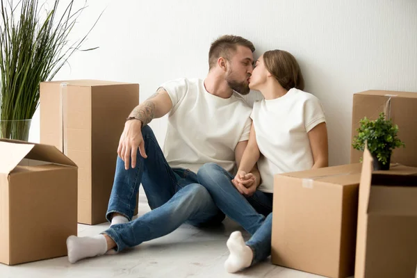 Loving young couple kissing, holding hands in new apartment — Stock Photo, Image