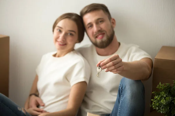 Portrait happy couple in new house with keys in hands — Stock Photo, Image