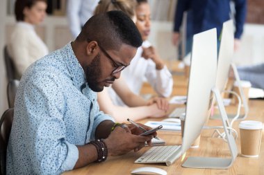 İşyerinde Smartphone kullanan ciddi Afrikalı-Amerikalı adam