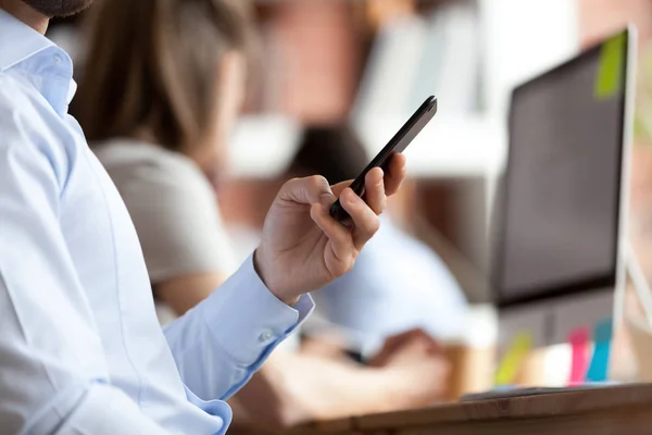 Businessman dialing number or typing message close up