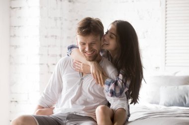 Genç mutlu çift evde yatak odasında beraber eğleniyor