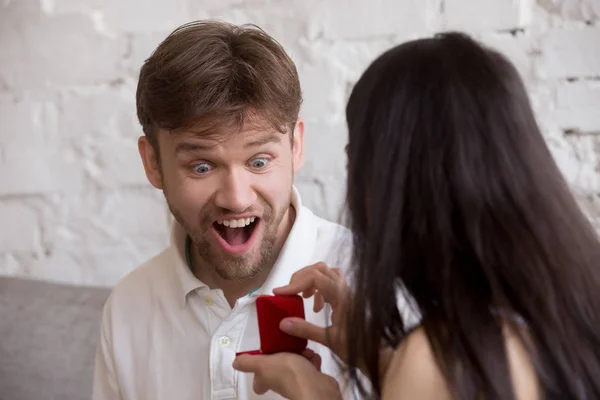 Woman doing proposal to excited surprised happy man