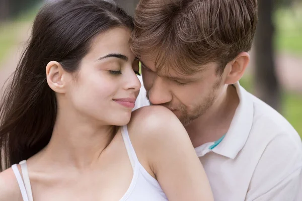 Amour homme baisers femme épaule avec tendresse dans le parc — Photo