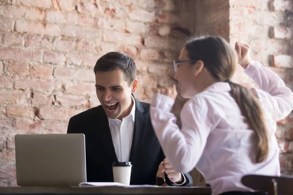 Захоплені офісні працівники кричать з радістю, дивлячись на ноутбук крик — стокове фото