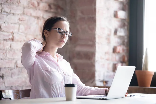 Donna d'affari stanca massaggiare muscoli del collo tesi sul posto di lavoro — Foto Stock