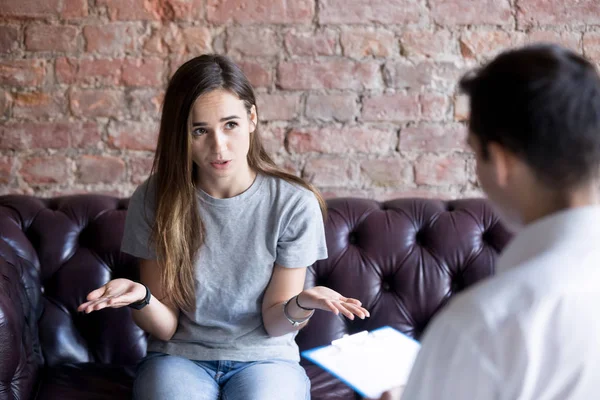 Unhappy young woman at a psychologist counselor reception. — Stock Photo, Image