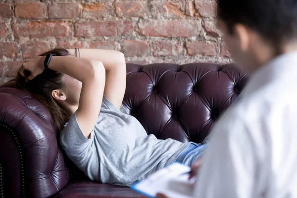 Mujer joven infeliz en una recepción psicóloga consejera . — Foto de Stock