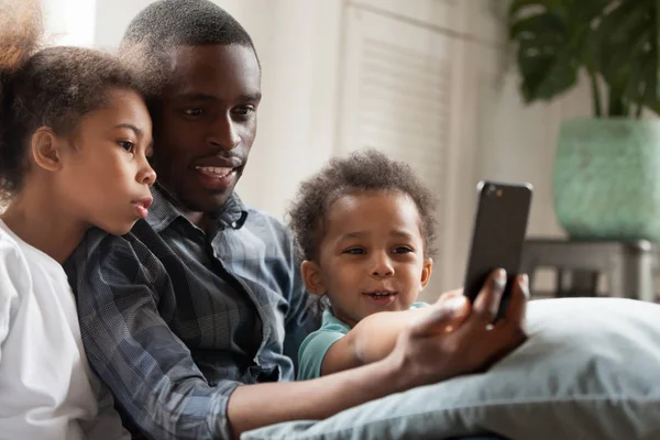 Famiglia afroamericana felice utilizzando il telefono cellulare insieme — Foto Stock