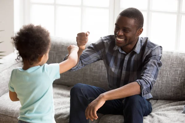 Gelukkig Afrikaanse Amerikaanse vader spelen met zoon thuis — Stockfoto