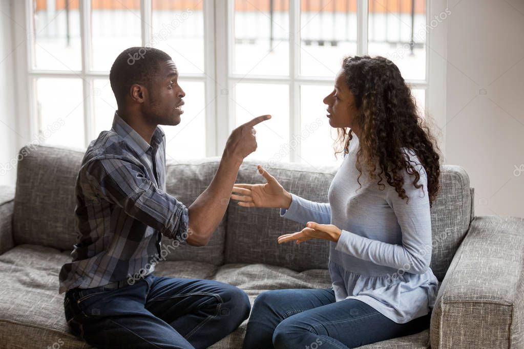 Irritated African American couple quarrelling at home
