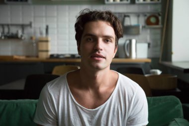 Kameraya bakarak kanepede oturan yakışıklı genç adam