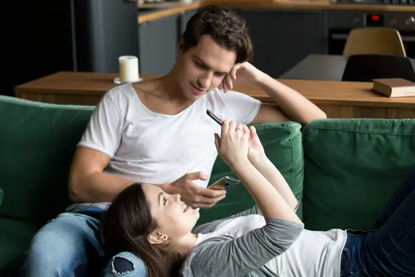 Young couple together with smartphones at home — Stock Photo, Image